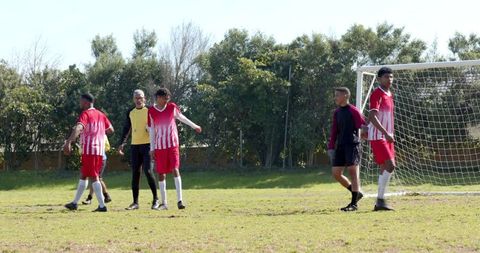 Multicultural soccer team preparing for penalty practice outdoors