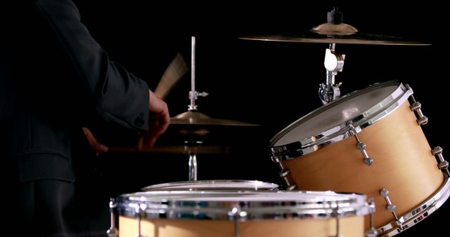 Drummer playing his drum kit on black background