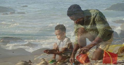 Black father and son building sandcastle on sunlit beach playing with buckets and shovels