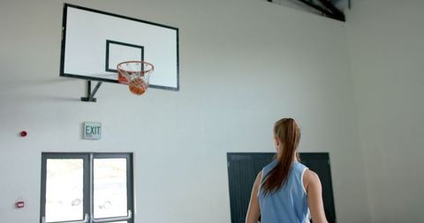 Female Basketball Player Focused on Scoring at Indoor Court