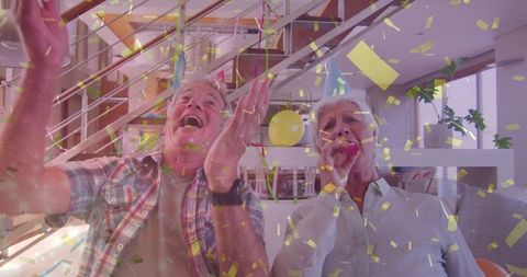 Joyful Senior Couple Celebrating Birthday with Video Call and Confetti
