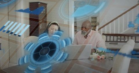 Couple collaborating on laptop while viewing augmented reality HUD overlay on dining table