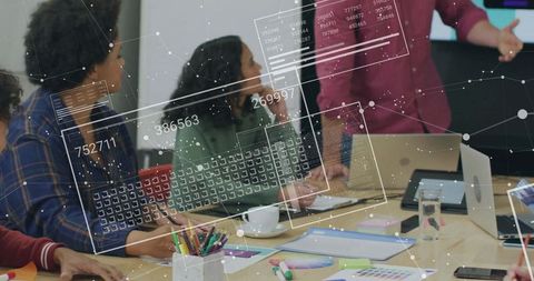 Team collaborating around meeting table while presenter explaining data visualization