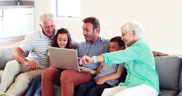 Three Generation Family Enjoying Time Together Using Laptop on Sofa - Download Free Stock Images Pikwizard.com