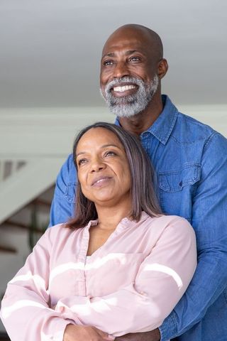 Mature african american couple embracing and smiling at home, cozy lifestyle