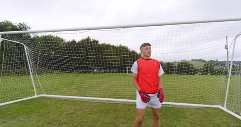 Teenage Goalkeeper Standing Intently on Soccer Field