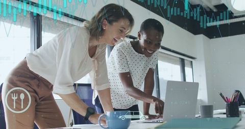 Diverse Businesswomen Analyzing Data on Laptop in Modern Office