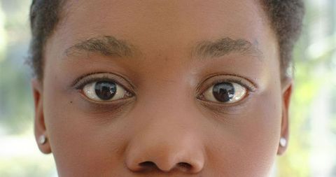Teenage female gazing with clear skin and stud earrings, closeup outdoor portrait