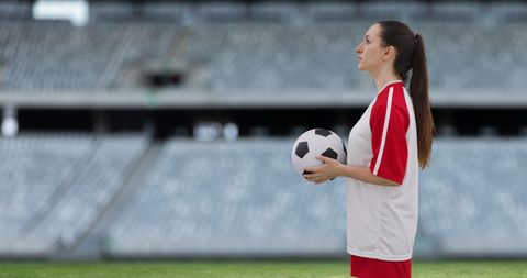 Focused Female Soccer Player Holding Ball in Stadium - Download Free Stock Images Pikwizard.com
