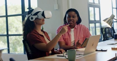 African American colleagues testing virtual reality collaboration tools in modern office