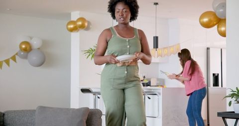 Diverse women preparing for birthday celebration at home