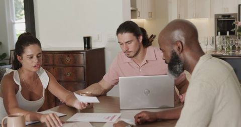 Diverse team planning wedding details at home table