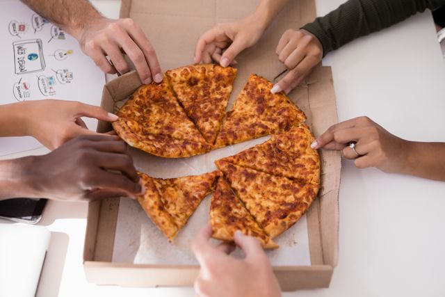 Close-up of executives sharing pizza in office