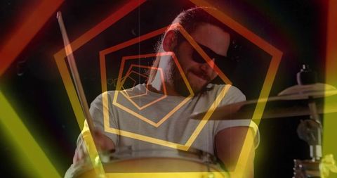 Playing drummer wearing sunglasses performing with neon pentagon overlay and motion blur