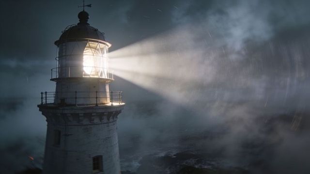 Old lighthouse beacon casting powerful beam through storm fog over rocky coast at night