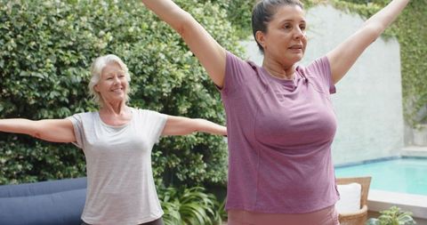 Poolside morning stretch class with senior and middle-aged women practicing gentle fitness