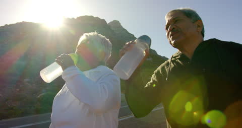 Senior Couple Enjoying Refreshment During Mountain Hike