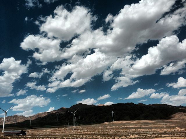 Wind Turbines in Desert Landscape Against Blue Sky with Puffy Clouds - Download Free Stock Photos Pikwizard.com