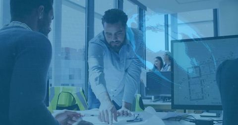 Bearded Project Lead Pointing at Blueprints Collaborating with Team in Modern Office and Planning