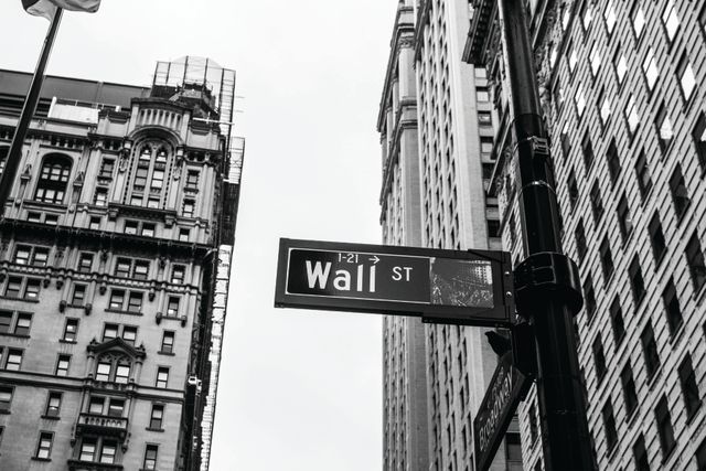 Monochrome image of Wall Street sign with historic buildings in the background. Ideal for projects related to finance, economics, New York tourism or architecture. Useful for editorial content, financial blogs, and educational materials.