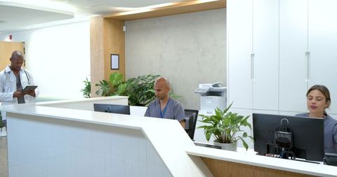 African American clinic reception staff working at modern medical front desk