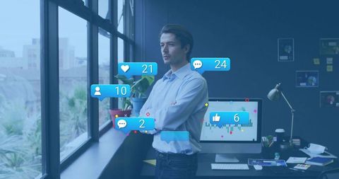 Businessman standing at window crossing arms gazing at monitor with social media analytics
