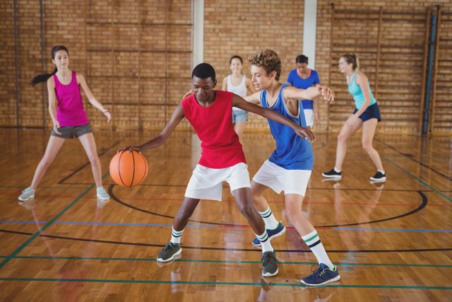 High school students playing basketball in a gymnasium, showcasing teamwork and competition. Ideal for use in educational materials, sports promotions, fitness campaigns, and youth activity advertisements.