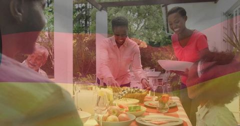 Multigenerational family serving outdoor brunch on sunlit backyard pergola table