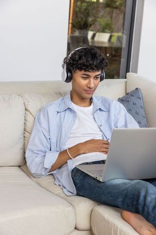 Young Man Enjoying Music with Laptop at Home