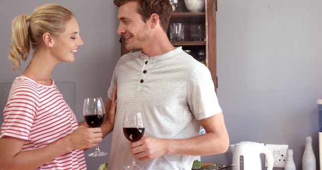 Couple drinking red wine while cooking 