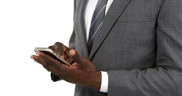 Businessman in formal grey suit and tie using smartphone. Ideal for use in business or tech-related contexts such as blogs, articles, presentation slides, or advertisements focused on professional communication and technology in the workplace.