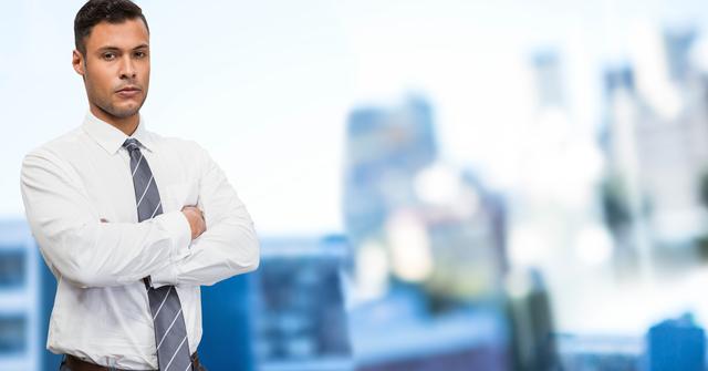 Confident Businessman Standing With Arms Crossed Against Office Background - Download Free Stock Photos Pikwizard.com