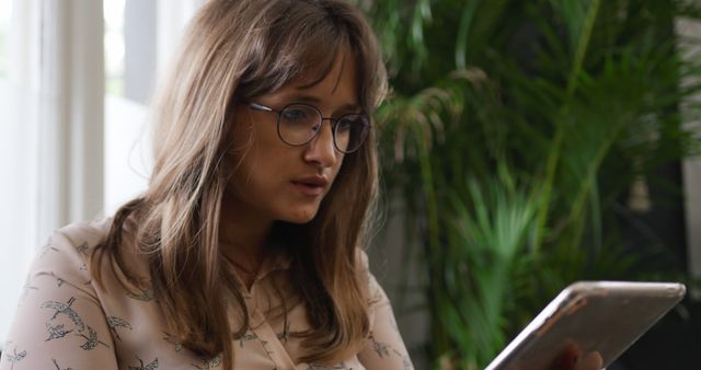 Young Woman with Glasses Reading Tablet in Modern Home - Download Free Stock Images Pikwizard.com