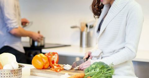 Woman Preparing Healthy Meal in Modern Kitchen with Fresh Vegetables
