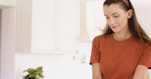 Woman Preparing Meal in Minimalist Kitchen with Natural Light
