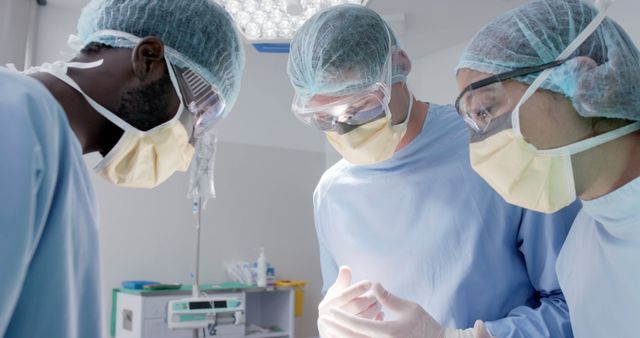 Diverse male and female surgeons with face masks during surgery. Medicine, healthcare and hospital, unaltered.