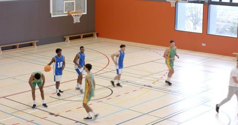 High School Basketball Players Practicing on Court Indoors