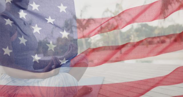 Image of waving flag of america over african american woman meditating on sunny beach. America, independence, celebration, tradition, holiday and patriotism concept digitally generated image.