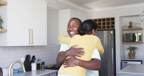 Young Couple Embracing Affectionately in Modern Kitchen