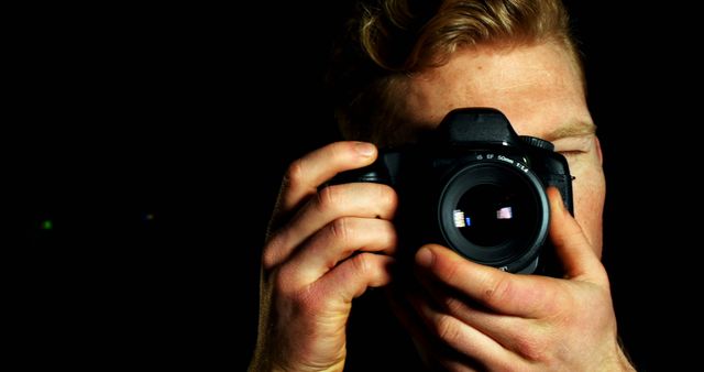 Photographer Holding Camera Focusing Lens with Black Background - Download Free Stock Images Pikwizard.com