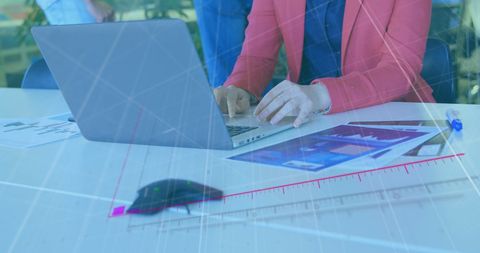 Businesswoman Analyzing Data on Laptop with Overlayed Graphs