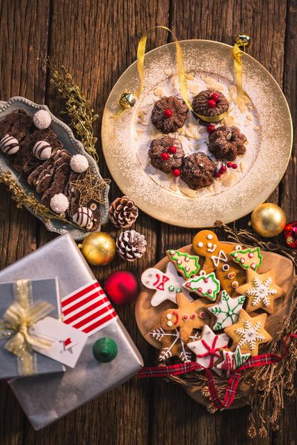 Close-up of various christmas desserts and gifts on wooden table