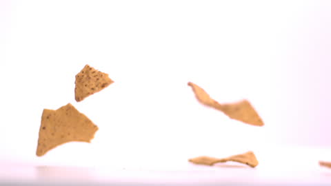 Tortilla Chips Falling on White Background in Slow Motion