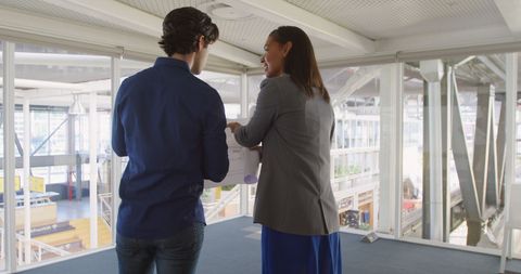 Business Creatives Discussing Architectural Plans in Modern Office