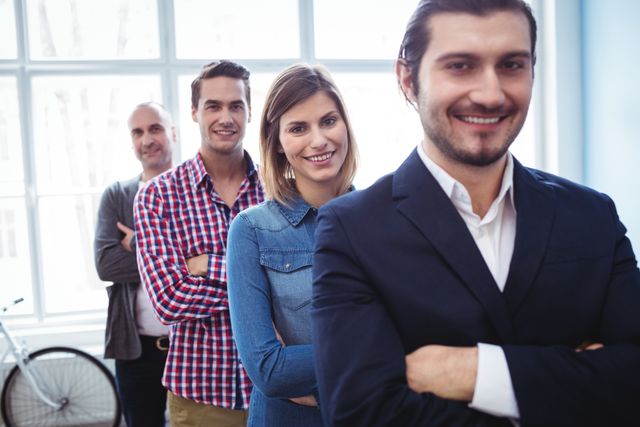 Portrait of smiling business people standing in row at creative office