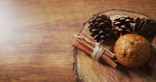 Image of christmas decorations with pine cones and cinnamon and cupcake on wooden background. christmas, tradition and celebration concept.