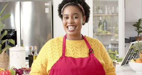 Cheerful Woman Cooking in Modern Kitchen Setting with Fresh Produce