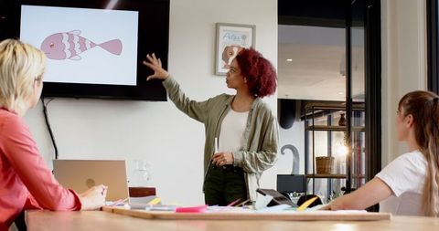Diverse Team Collaborating on Graphic Design Presentation in Office