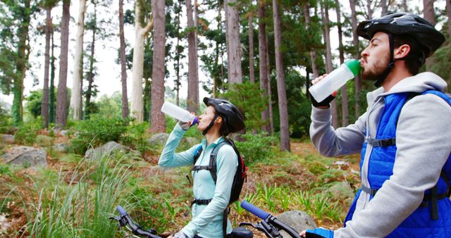 Couple Hydrating After Mountain Biking in Forest - Download Free Stock Images Pikwizard.com