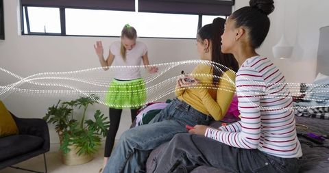 Teen girls hanging out in bedroom, dancing in neon green skirt, casual lifestyle